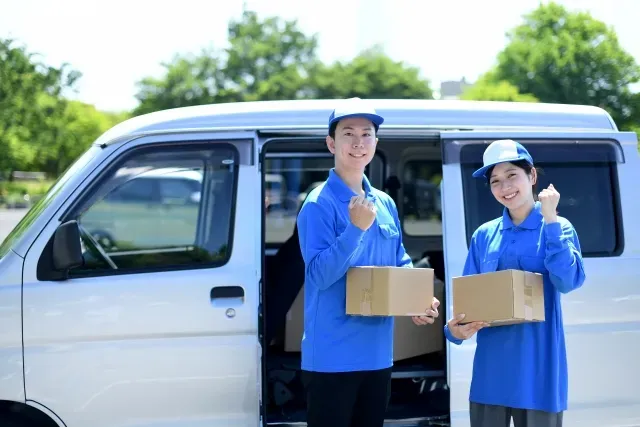作業車の前に立つ制服姿のスタッフ