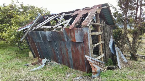 老朽化して倒壊しかけた物置小屋